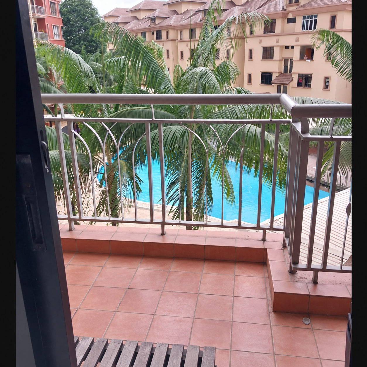 Balcony looking out to the swimming pool and landscaped greenery at Casa Indah 1